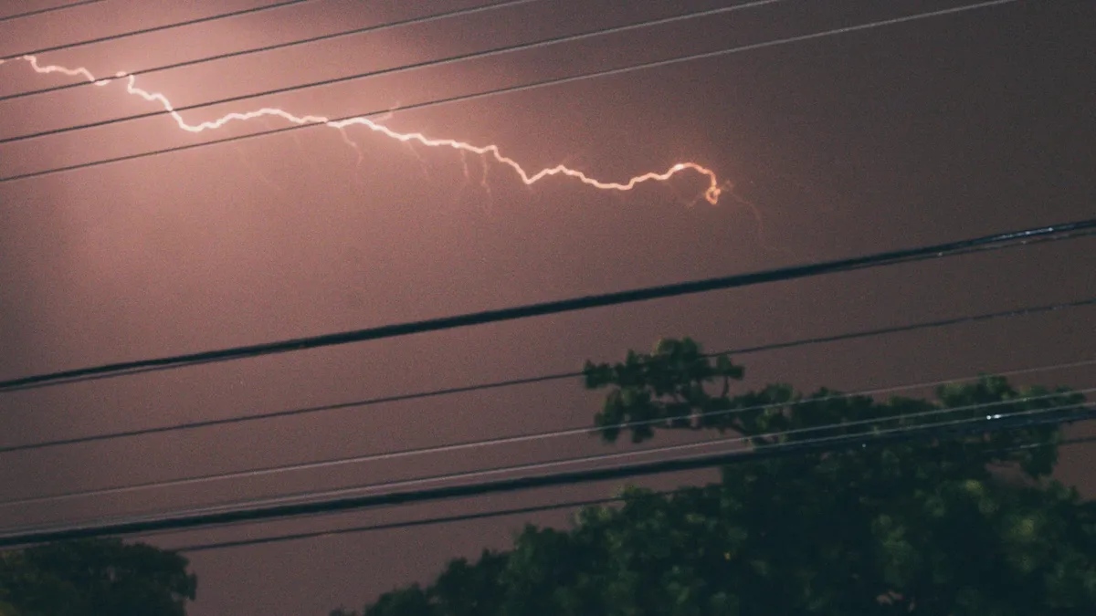 Raio cortando o céu noturno acima de fios da rede elétrica e copas de árvores, em Limeira (SP)